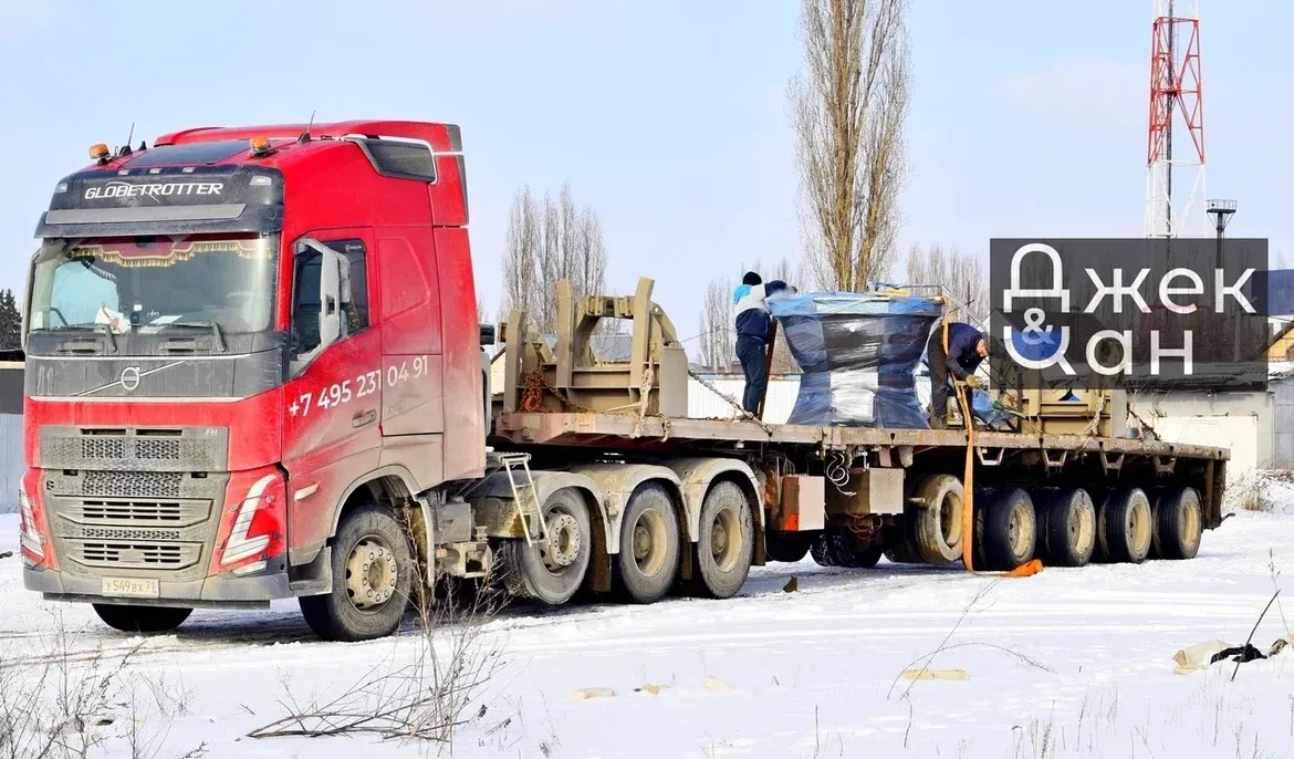 Грузовой автомобиль с чанами на длинном прицепе зимой